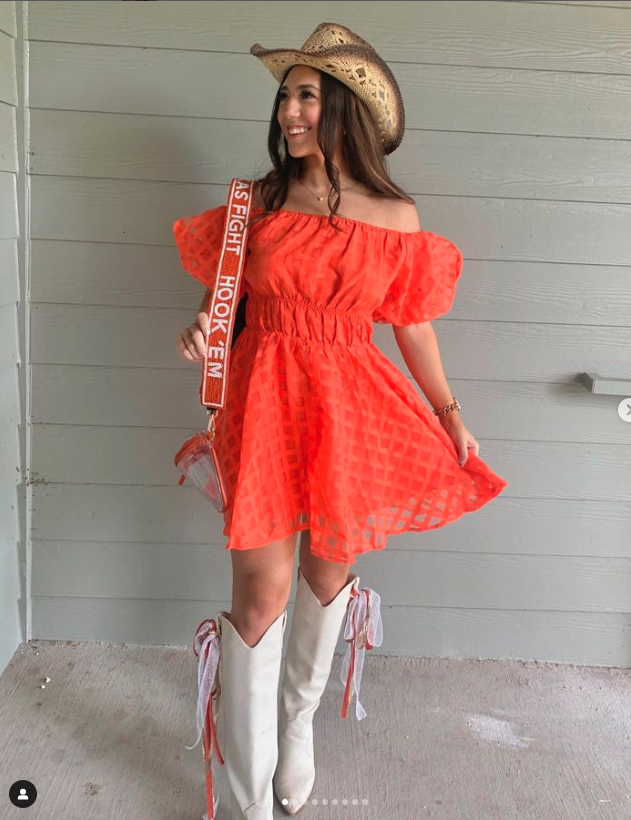 Texas Longhorn Fan in orange dress wearing beaded purse strap with clear purse from Desden 