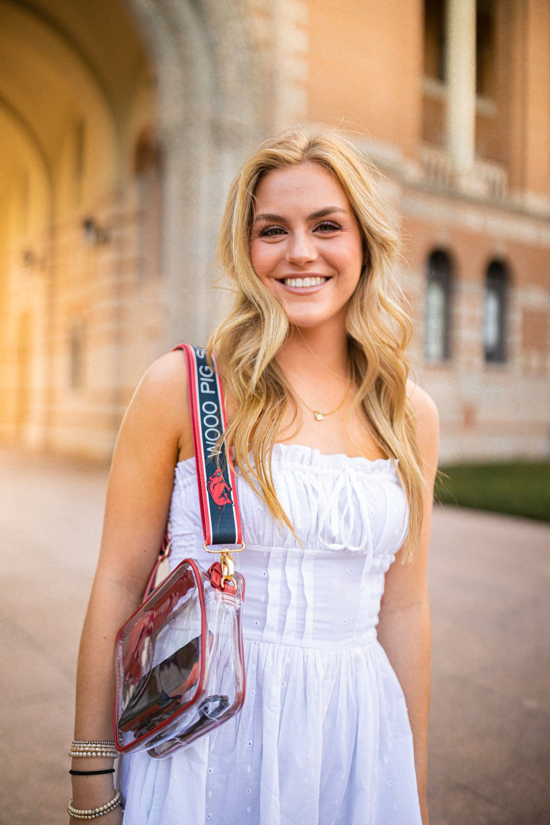 College girl wearing University of Arkansas Clear Purse with woo pig soooie purse strap